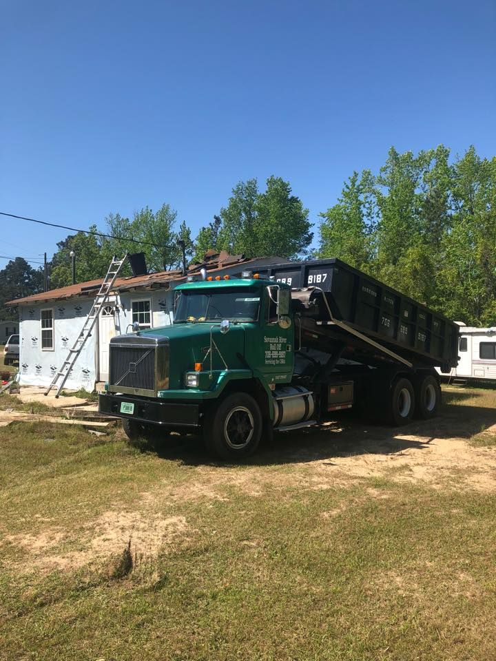 A dump truck is parked in front of a house.