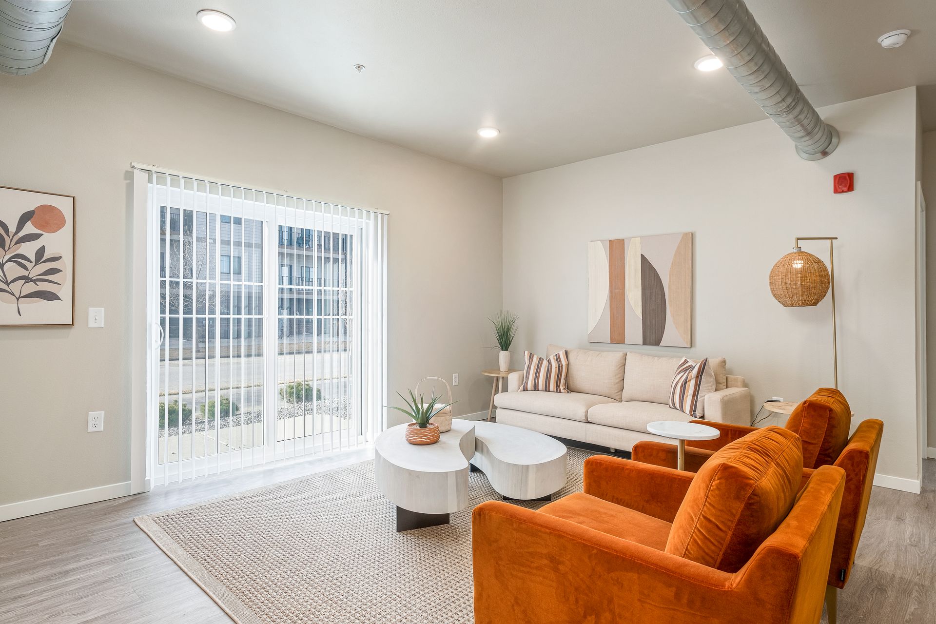A living room with a couch , chairs , coffee table and sliding glass doors.