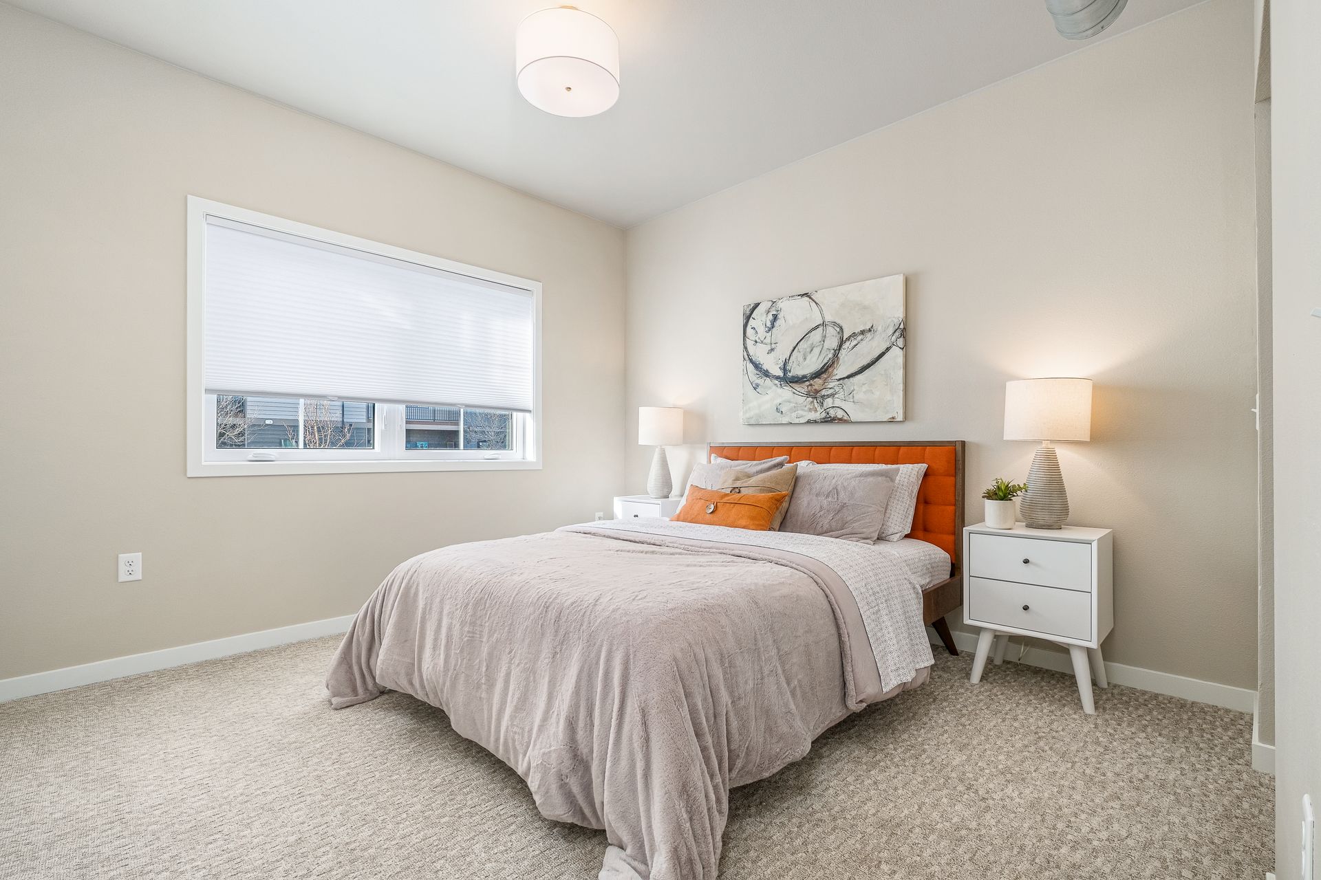 A bedroom with a bed , nightstand , and window.
