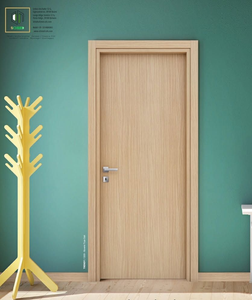 Una porta di legno centrata su una parete color verde acqua, accanto a un appendiabiti giallo, con un piccolo cartello nell'angolo.