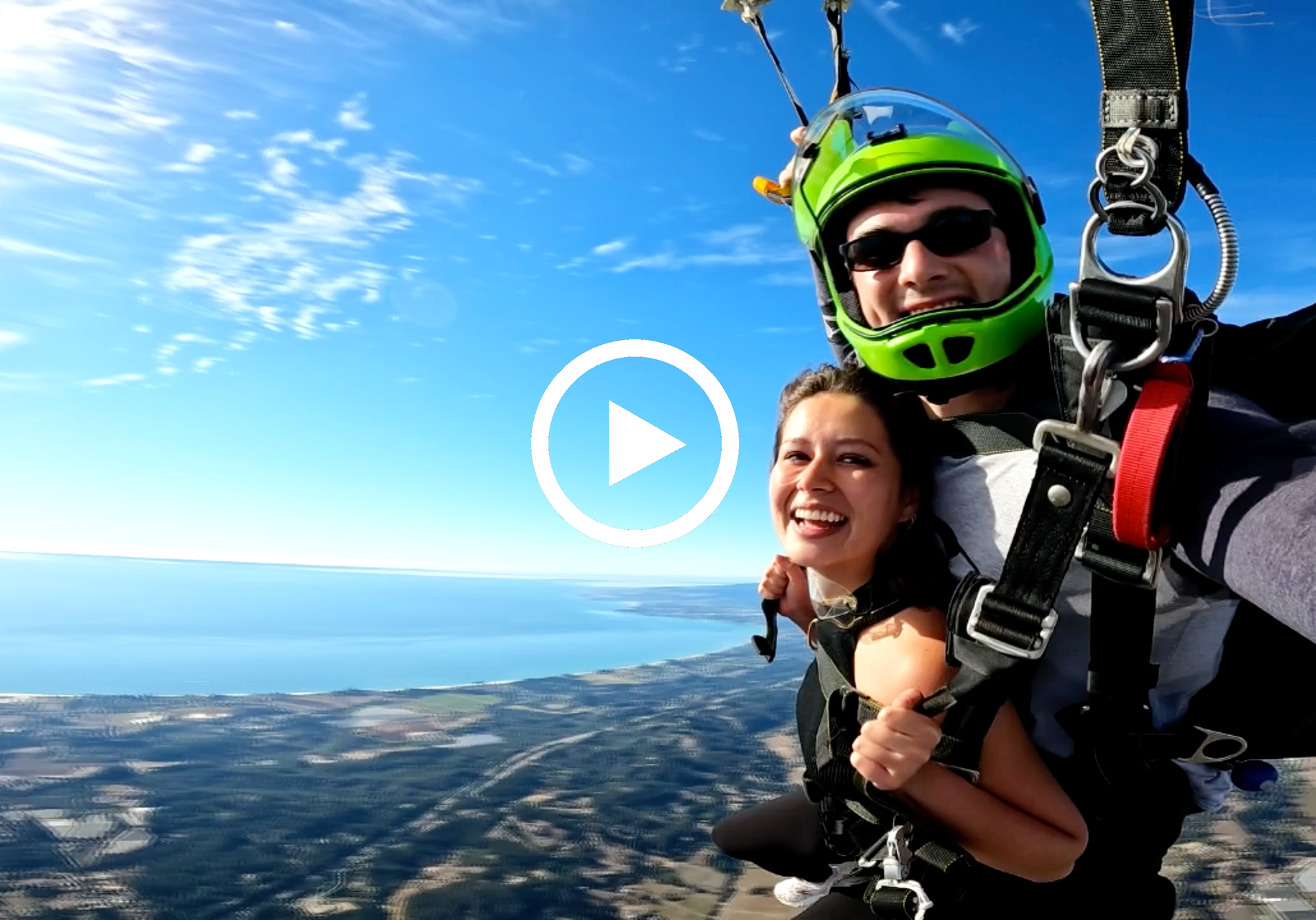 Video preview thumbnail of a tandem skydive pair during parachute descent with the ocean in the background.