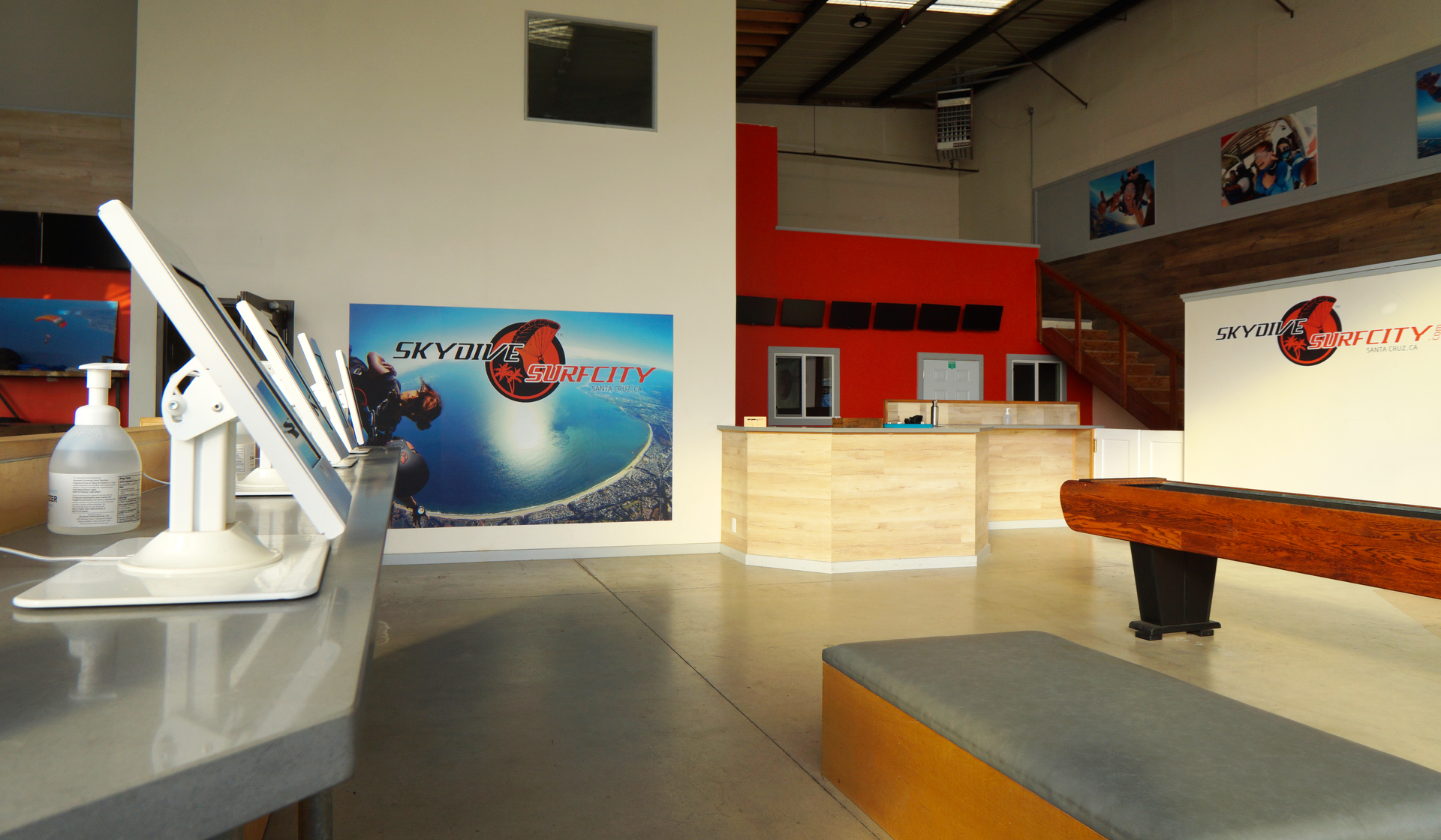 Inside the Skydive Santa Cruz facility showcasing digital check-in, benches and games area.