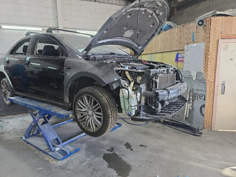 Black Car on a Lift With Hood Open in a Garage, Front Bumper Removed — T&C Smash Repairs In Coffs Harbour, NSW
