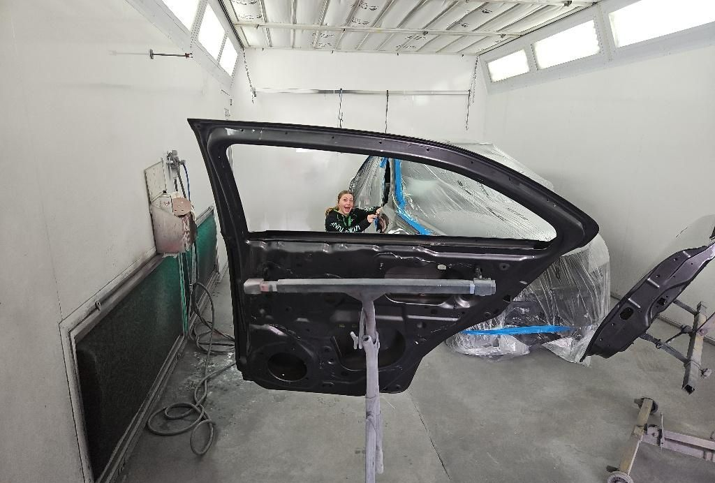 Car Door on a Stand in a Paint Booth, Being Worked on by a Person — T&C Smash Repairs In Coffs Harbour, NSW