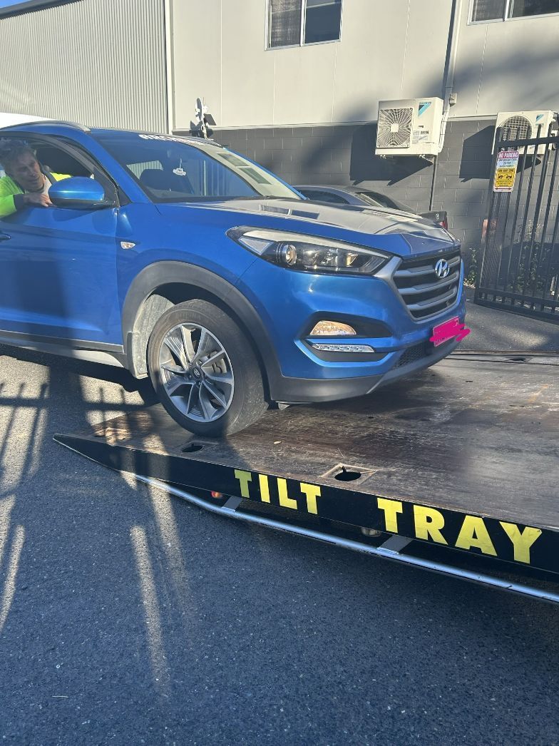 Blue Hyundai Tucson on a Tilt Tray Tow Truck — T&C Smash Repairs In Coffs Harbour, NSW