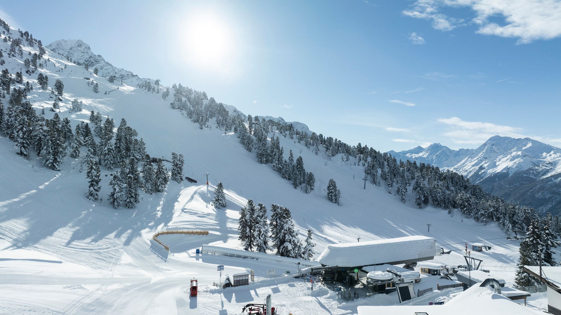 Die Sonne scheint hell auf die schneebedeckten Berge in Hochötz