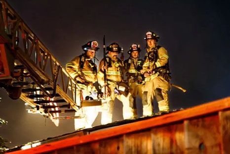 A group of maintenance team are standing on top of a ladder.