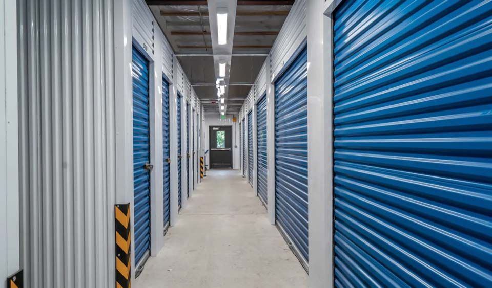 A hallway filled with rows of blue storage units.