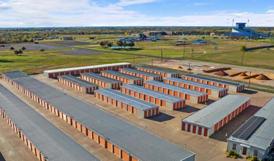 An aerial view of a row of storage units in a field.