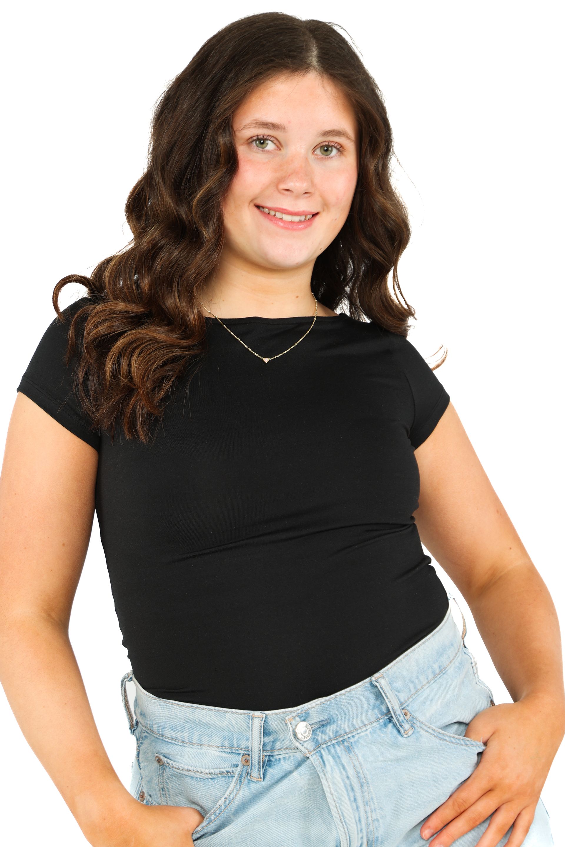 Woman in a black shirt and light jeans smiling against a white background