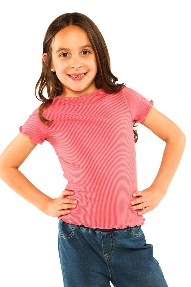 Smiling child in a pink shirt and jeans, standing with hands on hips against a white background