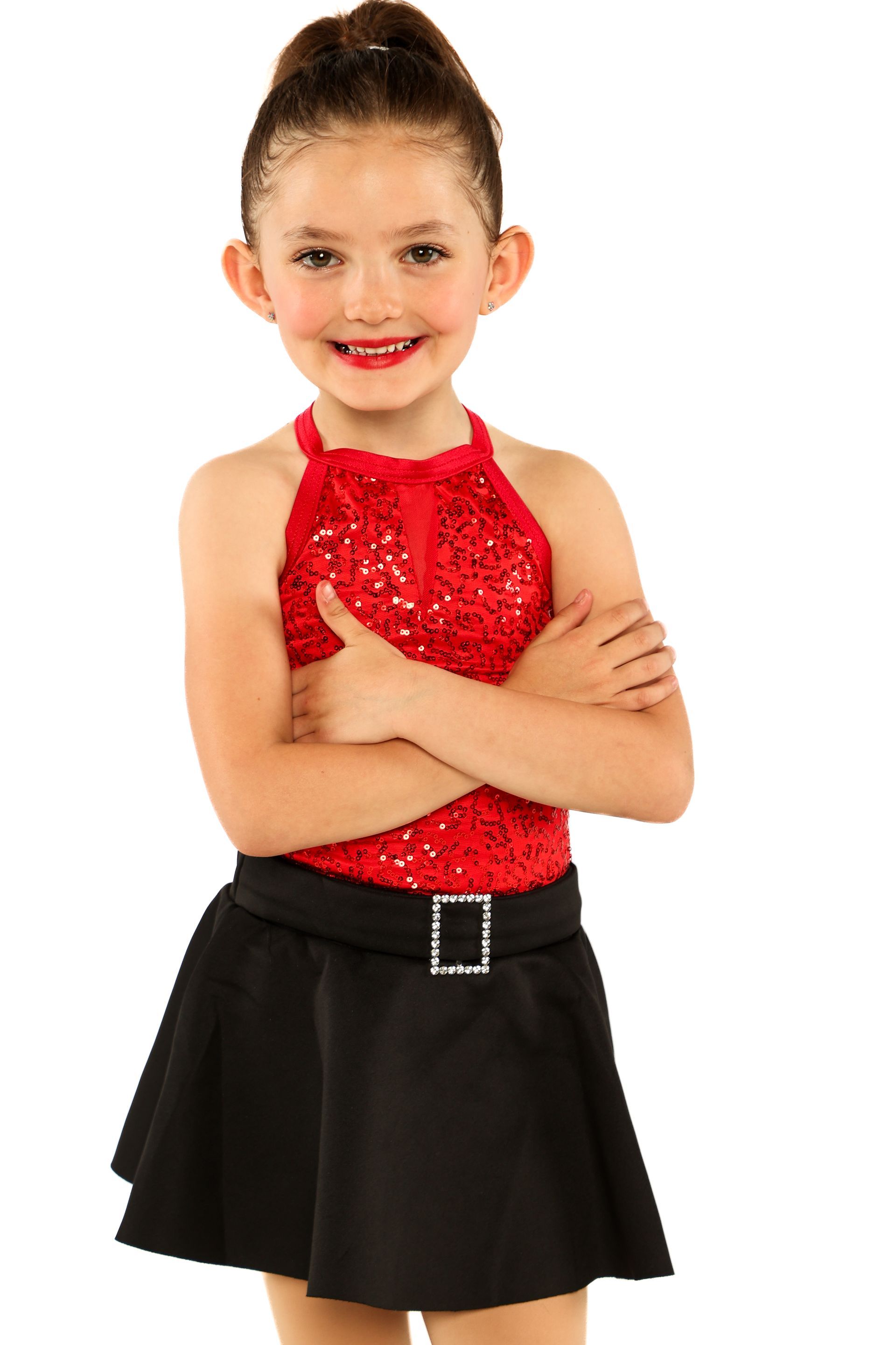 Child in red sequined top and black skirt, arms crossed, smiling against a white background