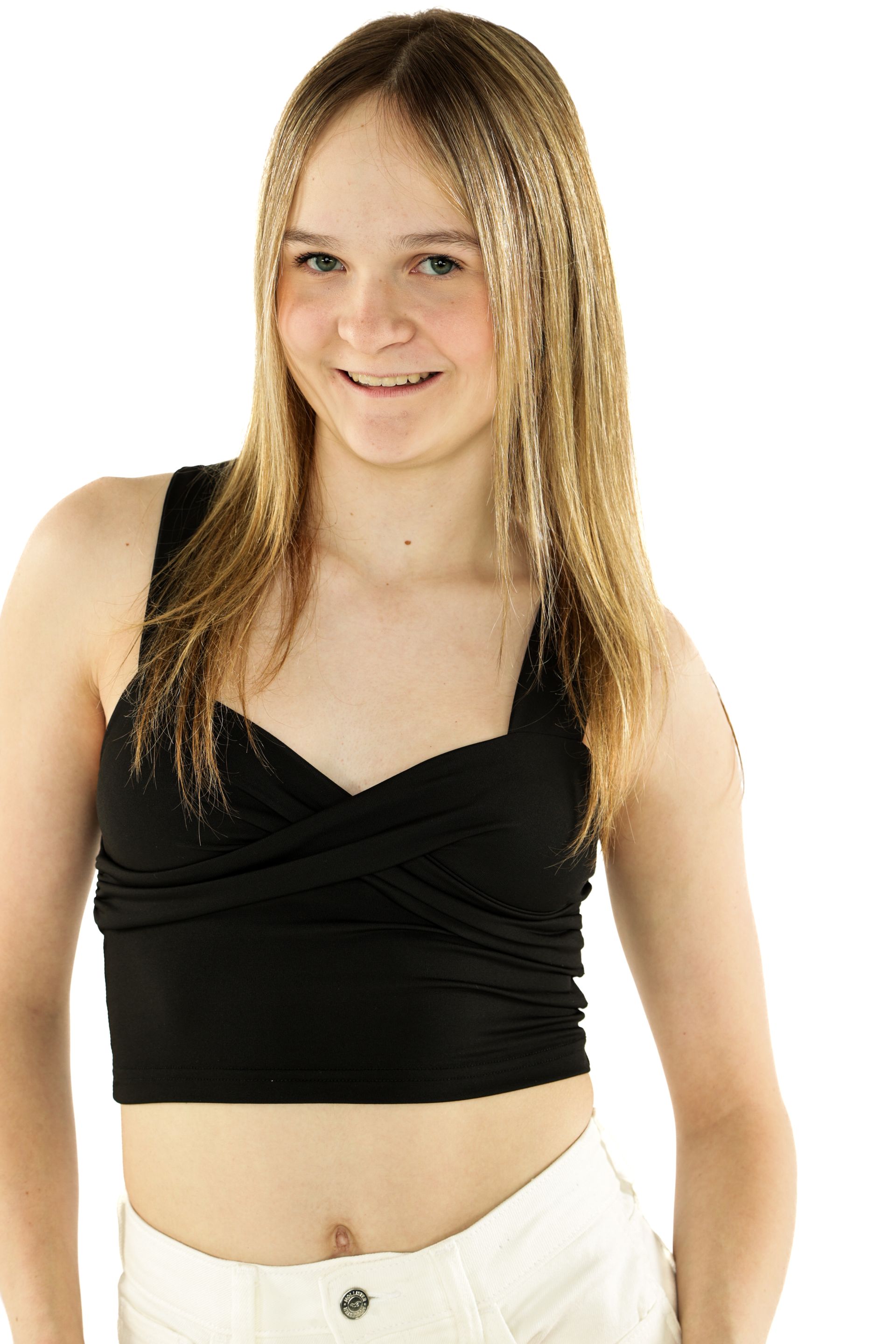Person standing against a white background, wearing a black top and light pants, smiling at the camera.