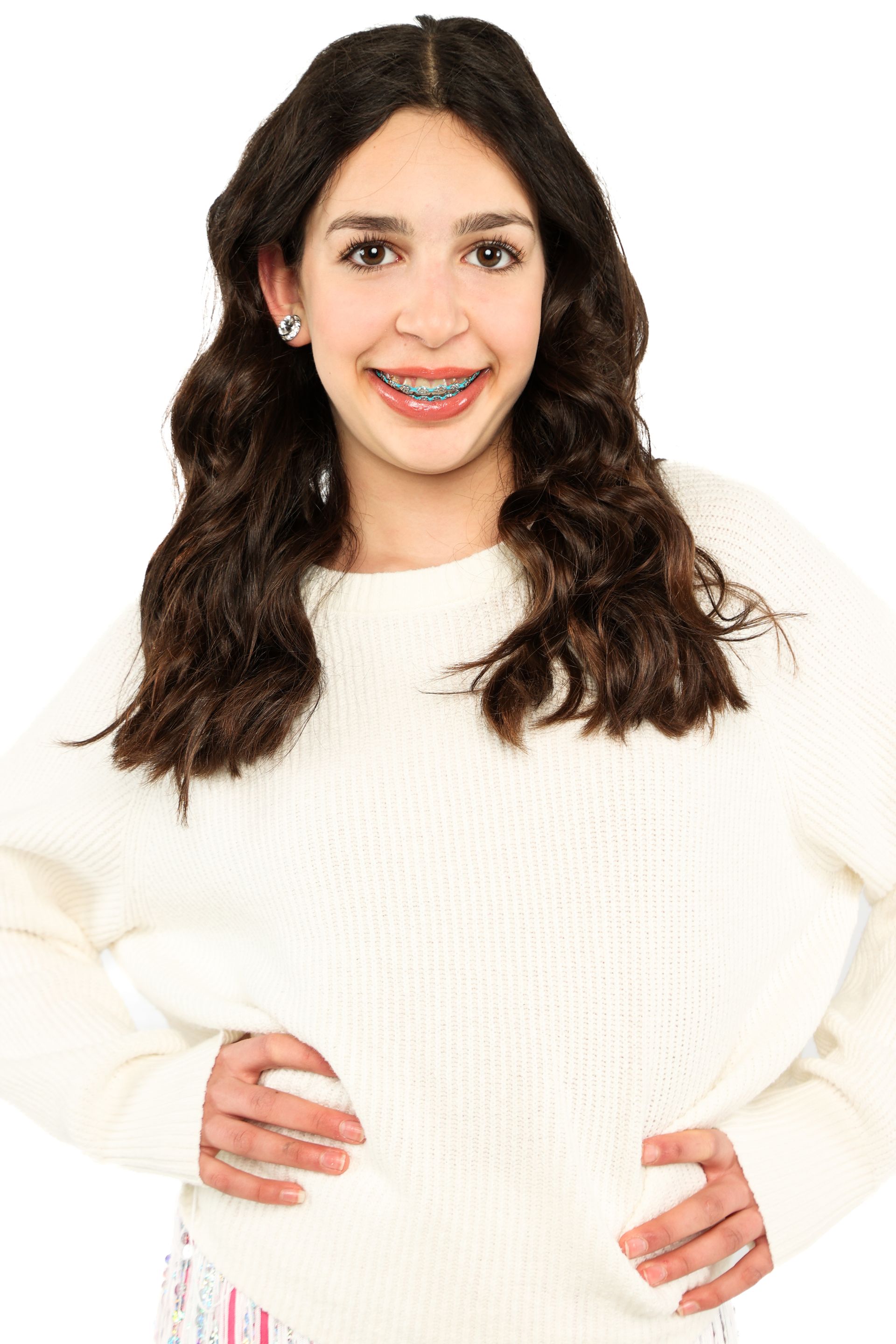 Smiling woman with long dark hair wearing a white sweater on a white background