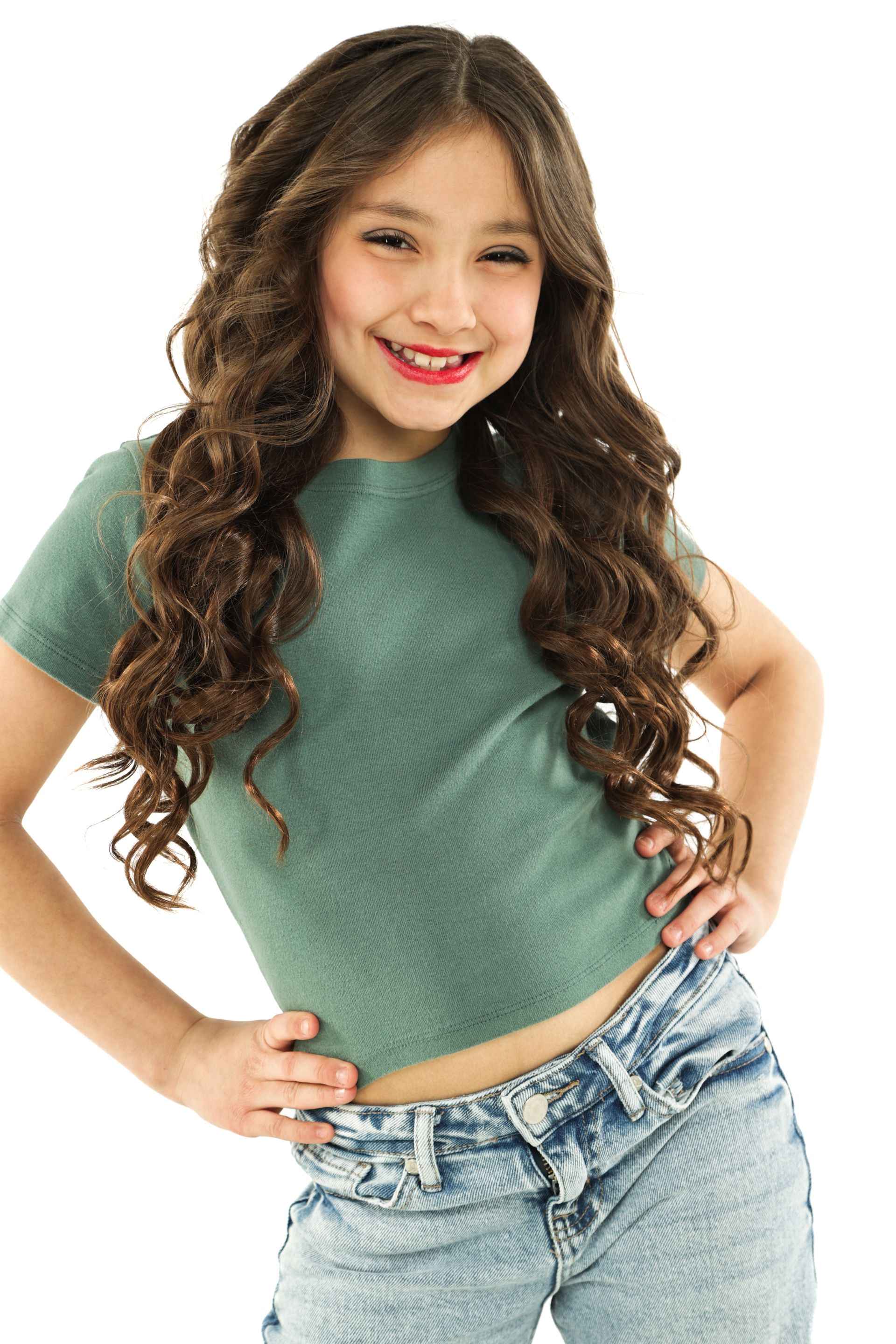 Smiling person in a green top and light jeans posing against a white background