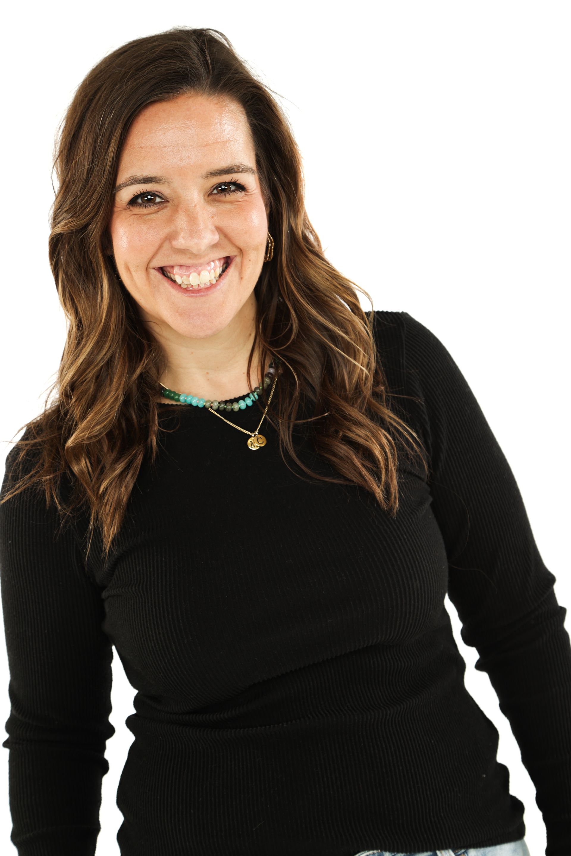 Smiling person with long dark hair in a black top against a white background
