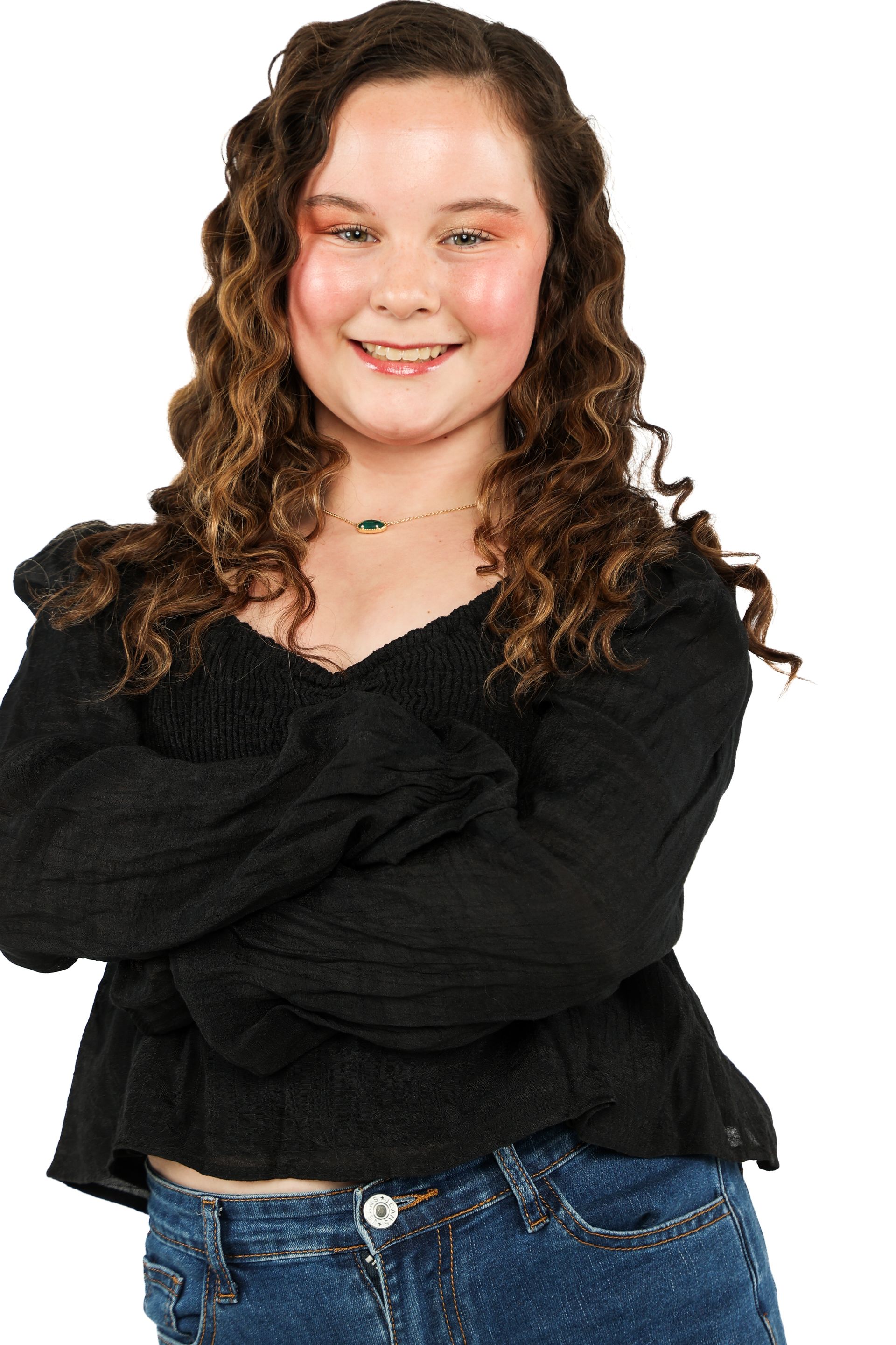 Smiling person in a black top and blue jeans with arms crossed against a white background