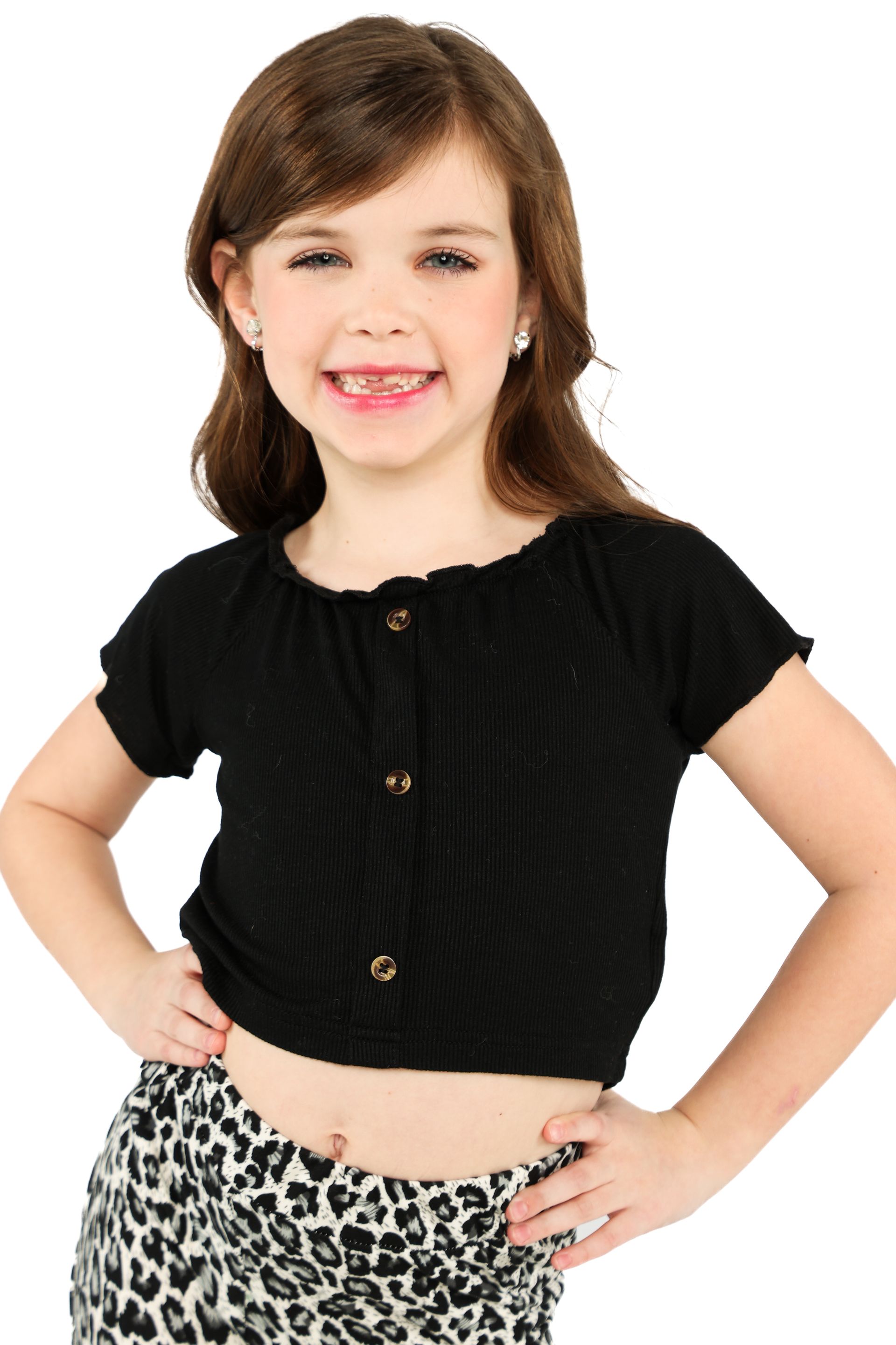 Girl posing in a black top and leopard-print pants against a white background