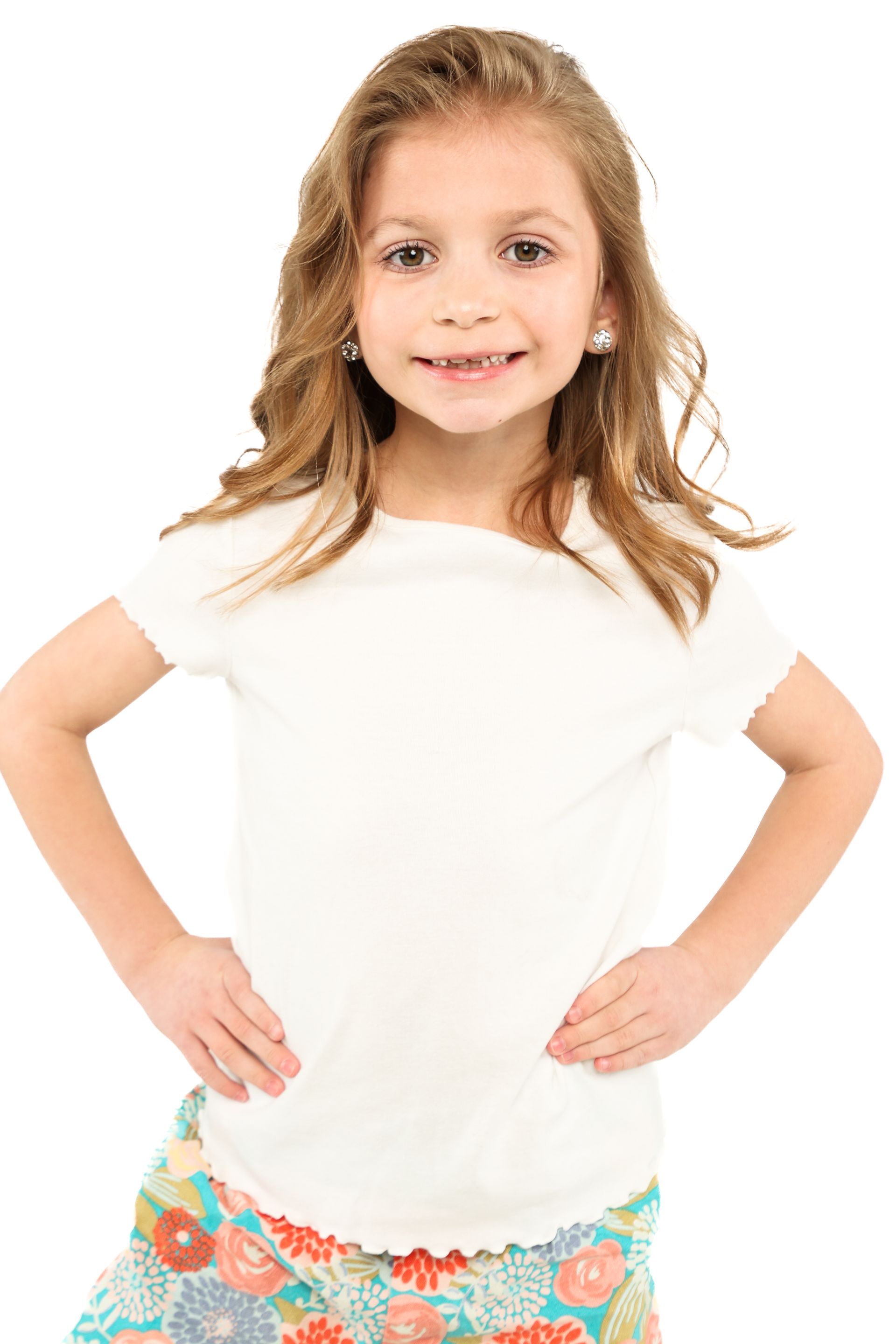 Smiling child in a white shirt and colorful skirt, standing with hands on hips against a white background