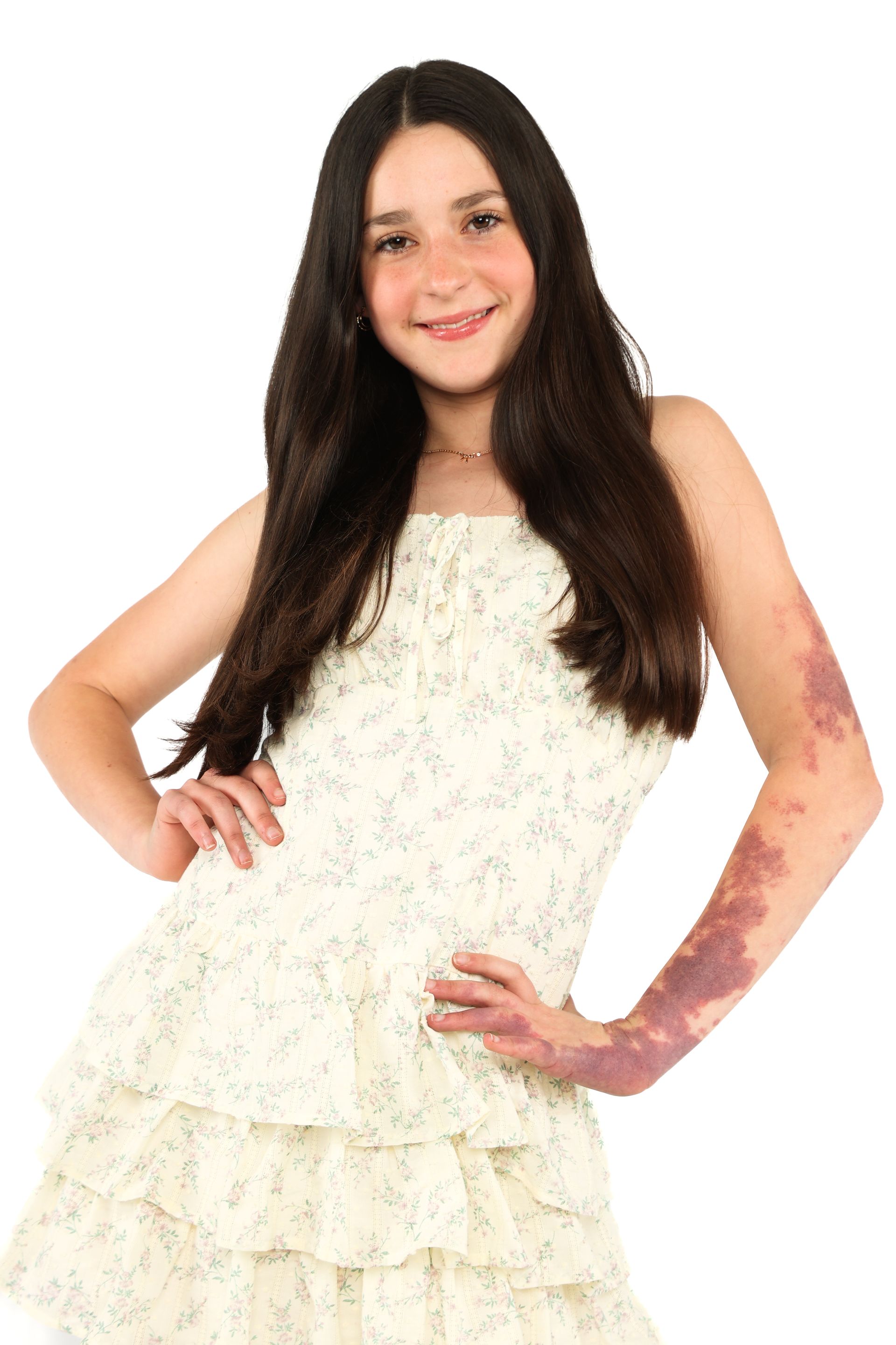 Person in a white layered dress posing with one hand on hip against a white background