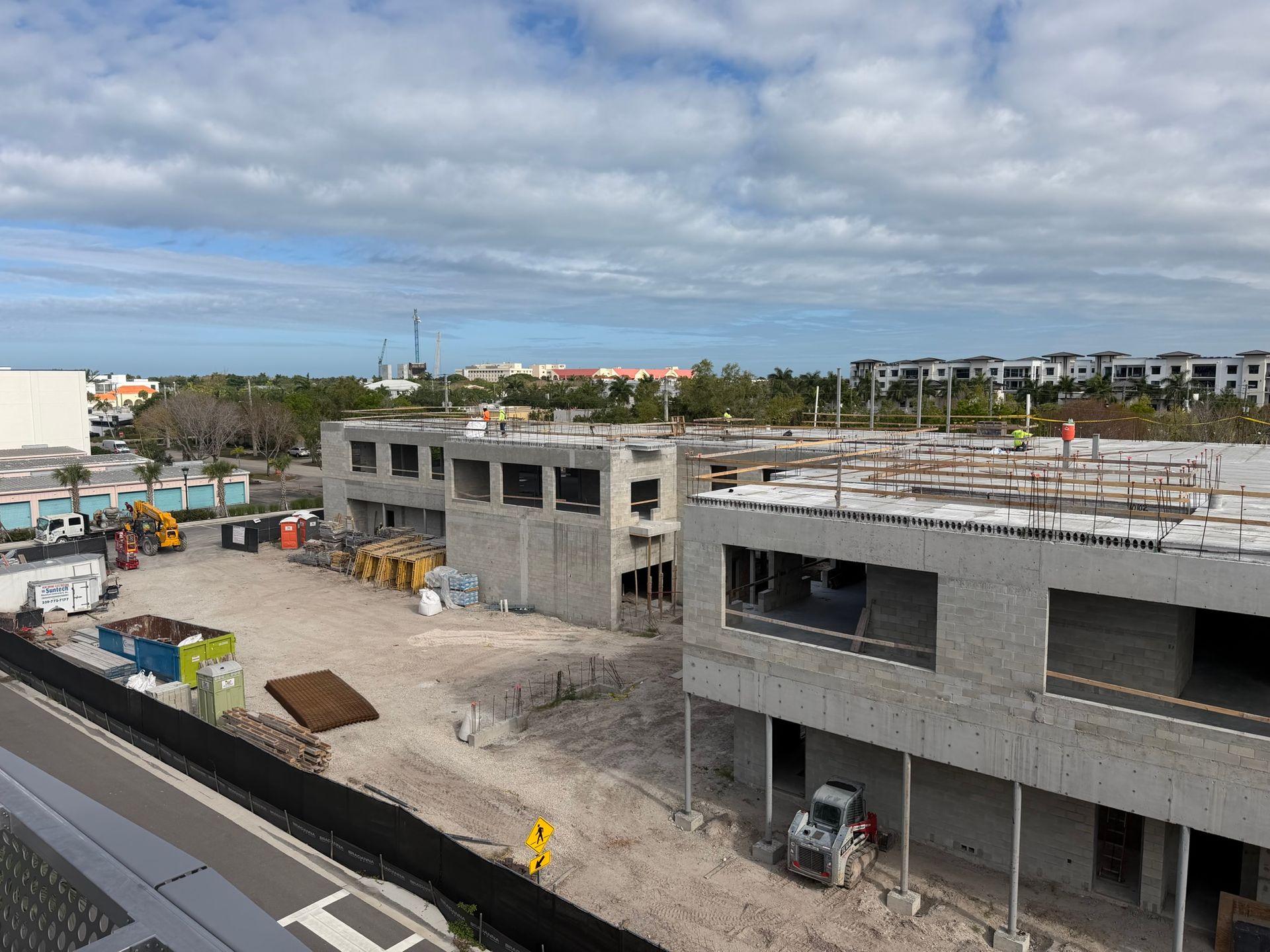 Construction site with unfinished concrete buildings under a cloudy sky