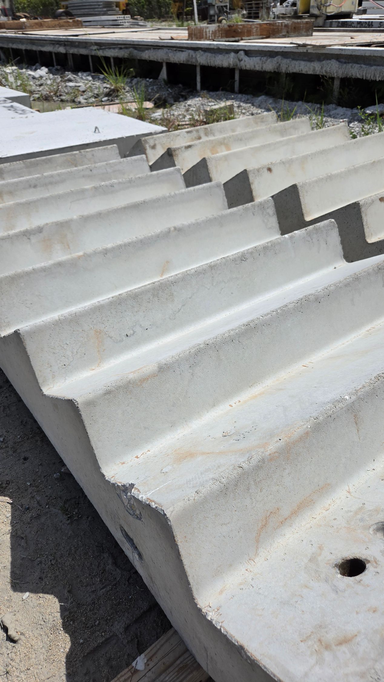 Stacked white corrugated metal sheets outdoors on a construction site.