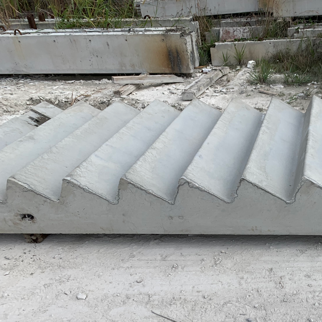 Concrete steps with corrugated treads in a dusty outdoor construction area