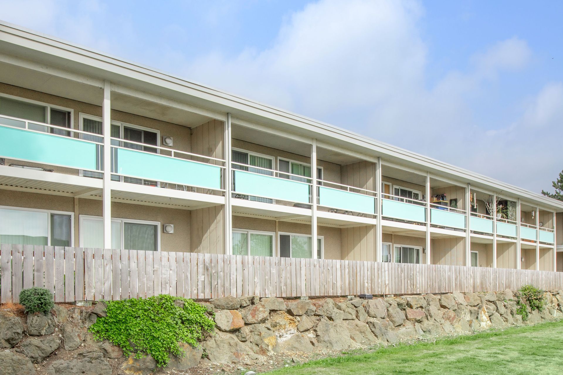 A large apartment building with balconies and a wooden fence