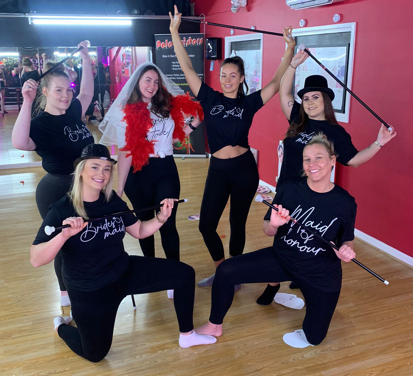 Hen party dance group in a studio in Cardiff wearing “Bride to Be” and “Bride Squad” outfits, posing with canes in a fun 1920s Charleston-style dance class atmosphere