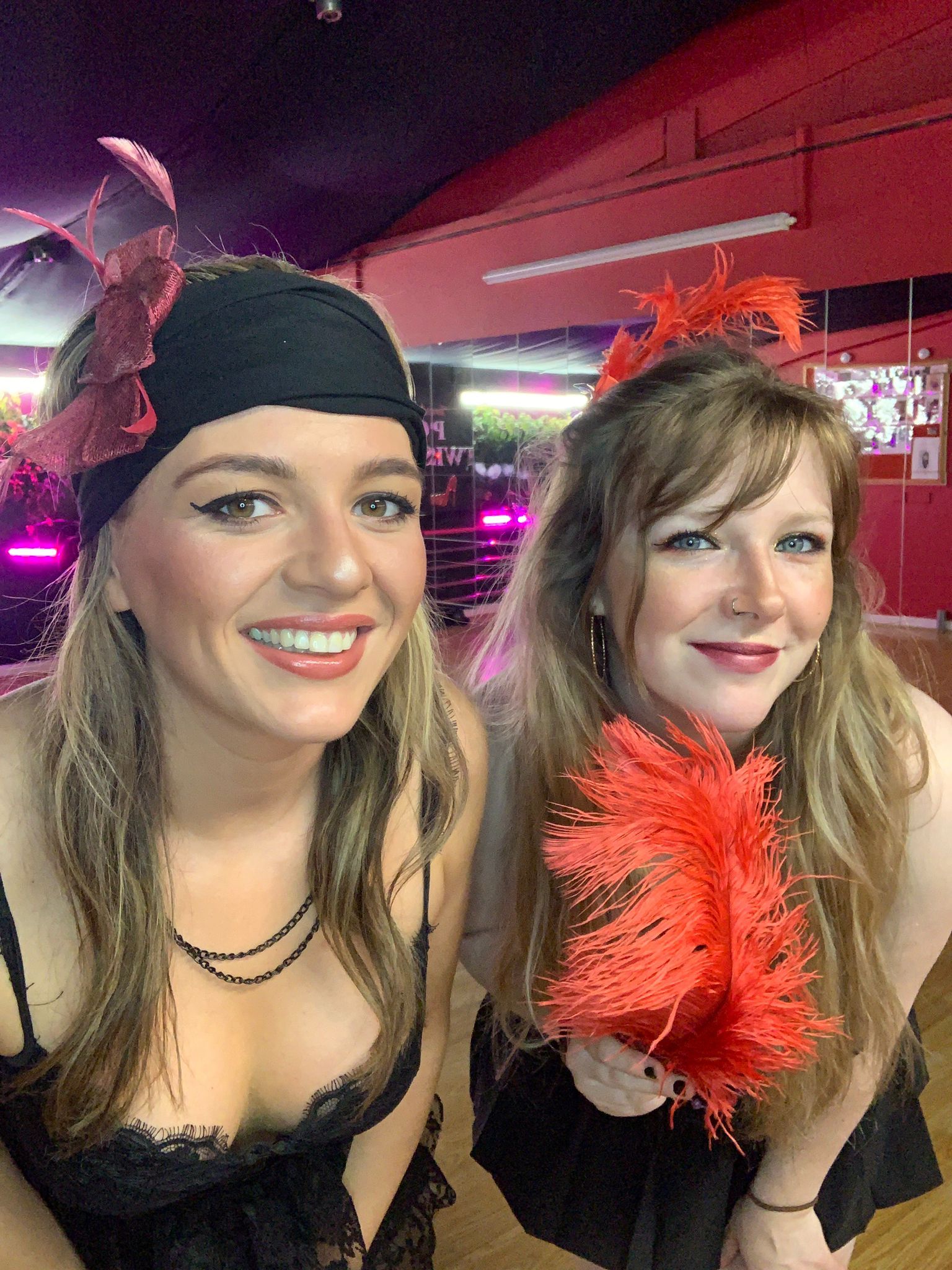 Hen party guests smiling in 1920s themed accessories including feather boa during a fun Charleston dance class experience in Cardiff, South Wales