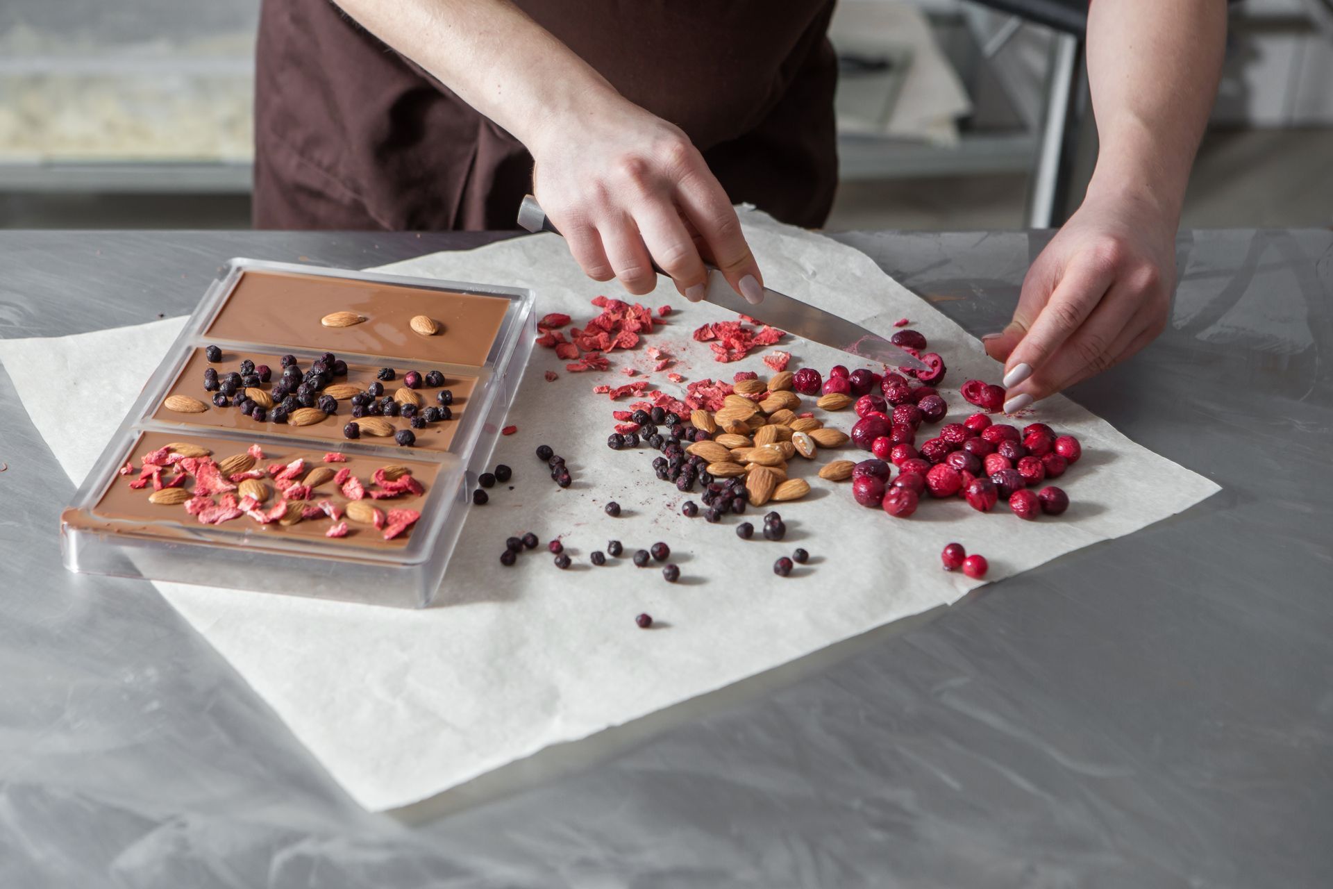 Chocolate making workshop with hands preparing handmade chocolates on a work surface
