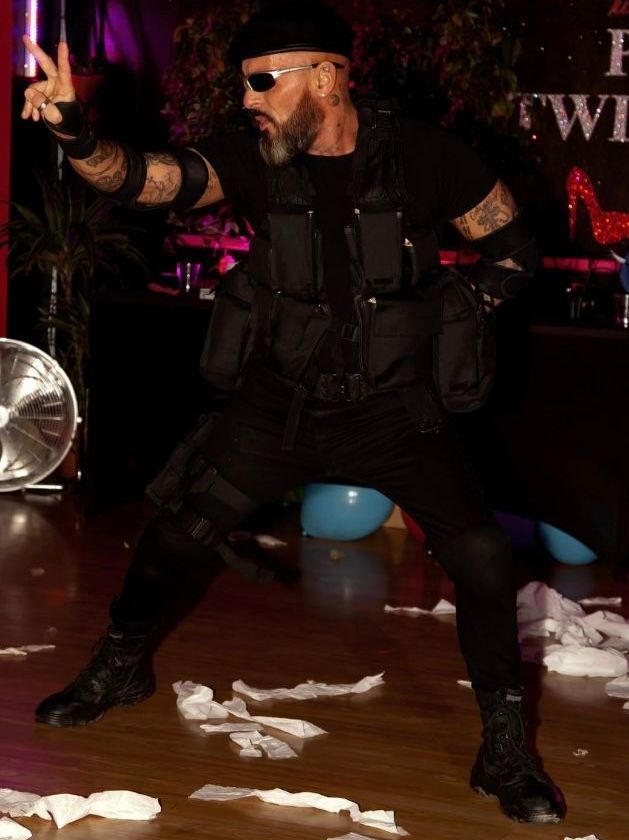 Male strip performer in a themed costume delivering a dramatic stage routine at a hen party