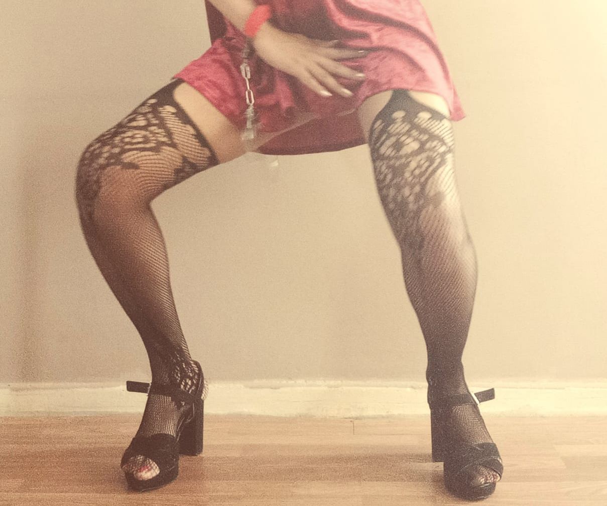 Trans hostess in fishnet stockings and high heels entertaining guests during a handcuffed bar crawl and stag party challenge. Perfect for stag nights, birthday parties, drinking games and hilarious group entertainment across the UK.