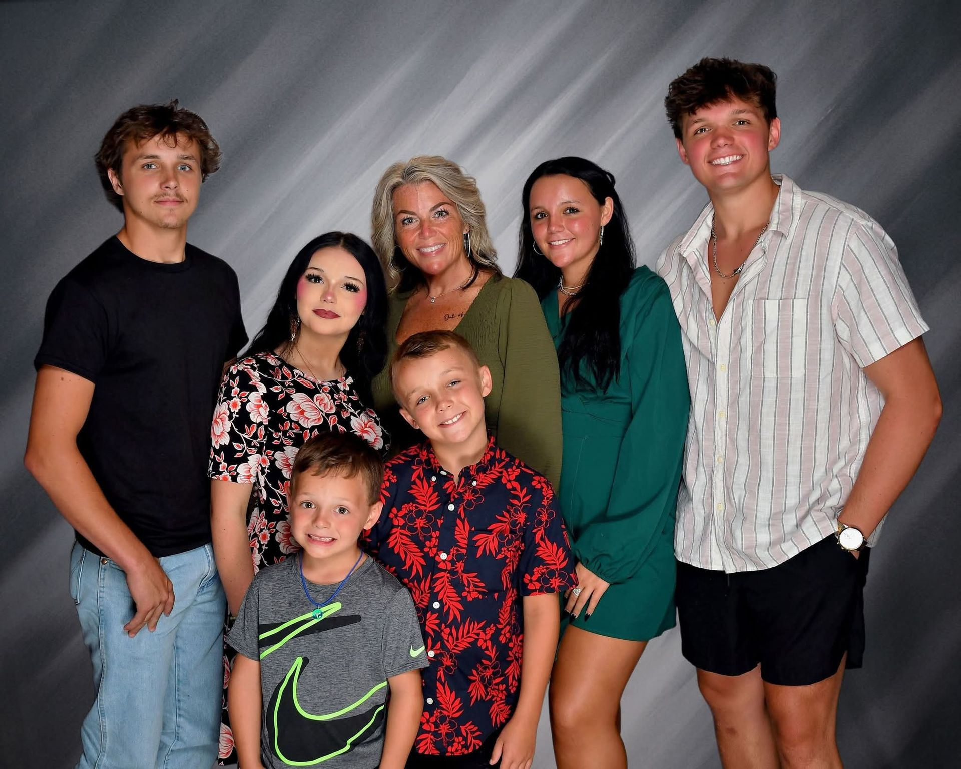 A large family is posing for a picture in a field.
