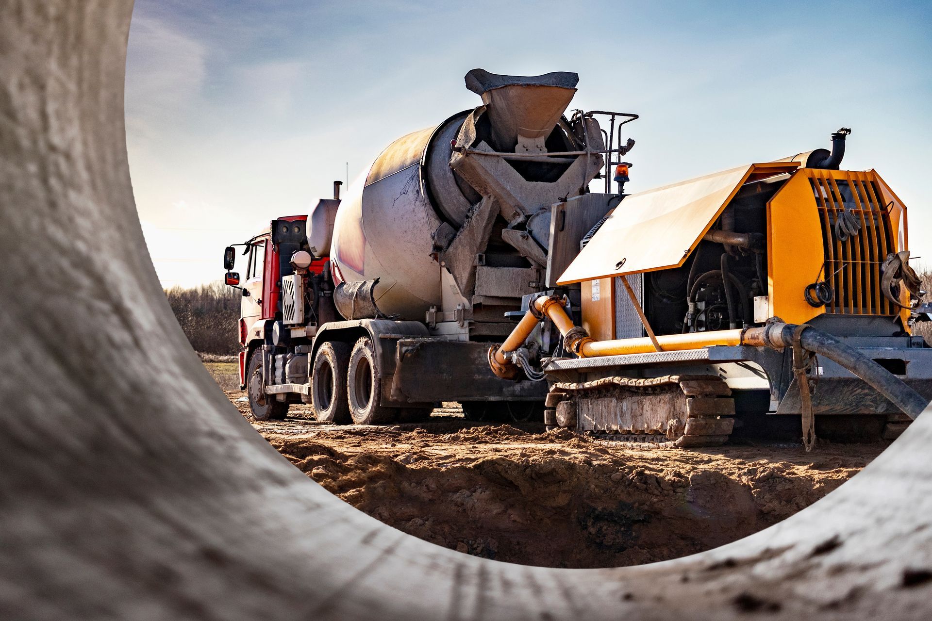Concrete mixer truck pouring concrete into a construction machine.