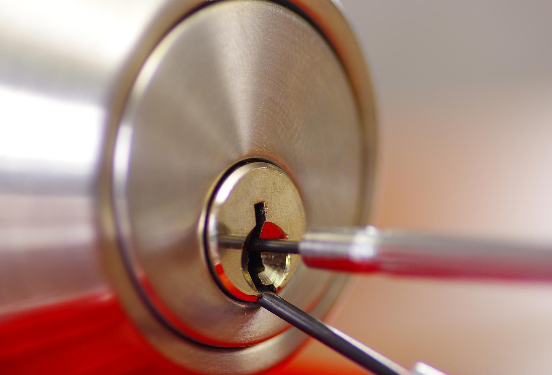 Close-up of locksmith tools working inside a commercial door lock cylinder.