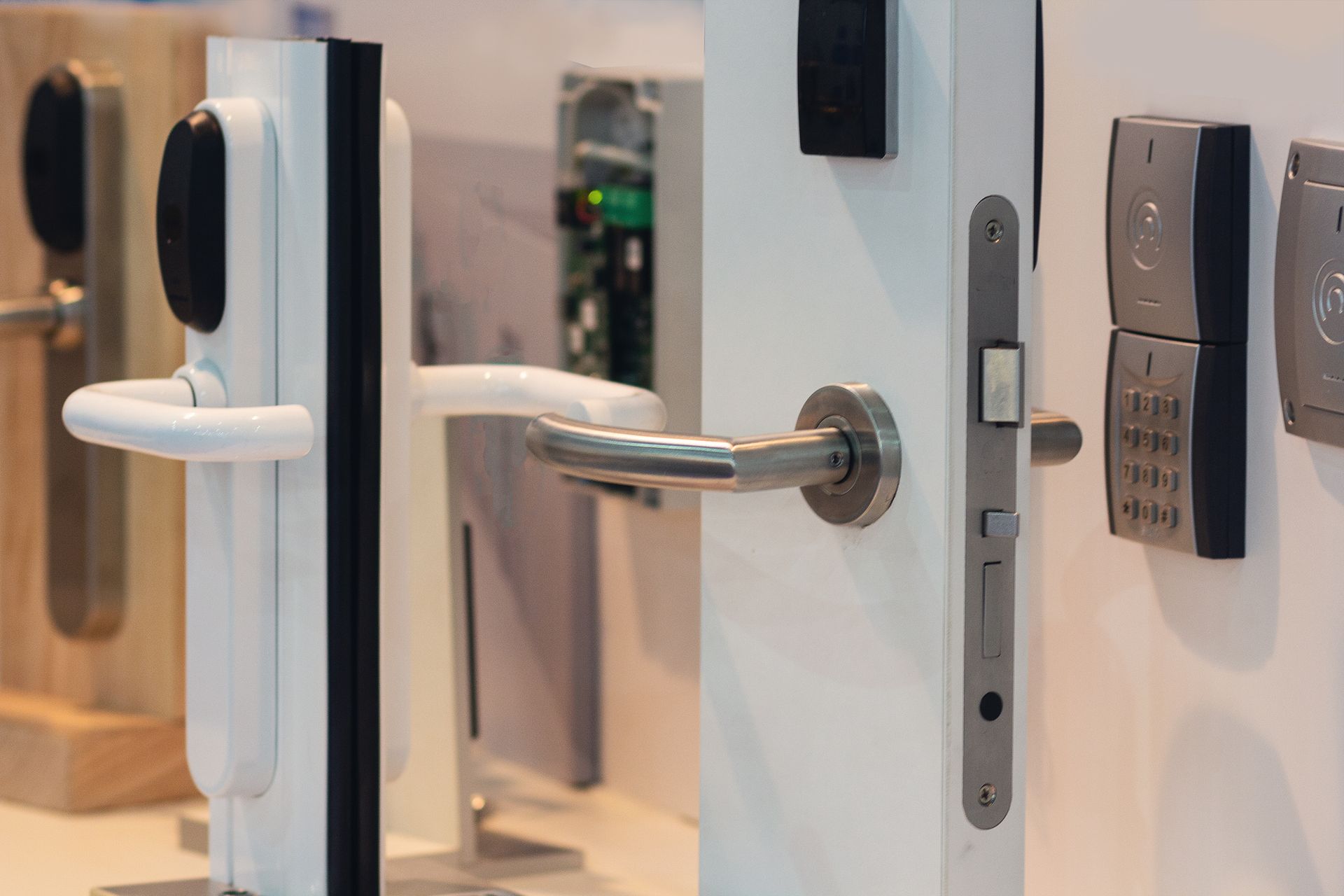A variety of modern door locks and handles mounted on display panels.