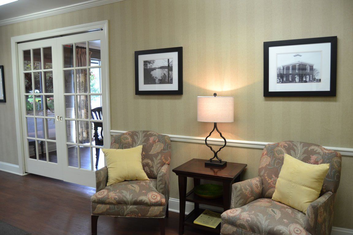 A living room with two chairs and a lamp