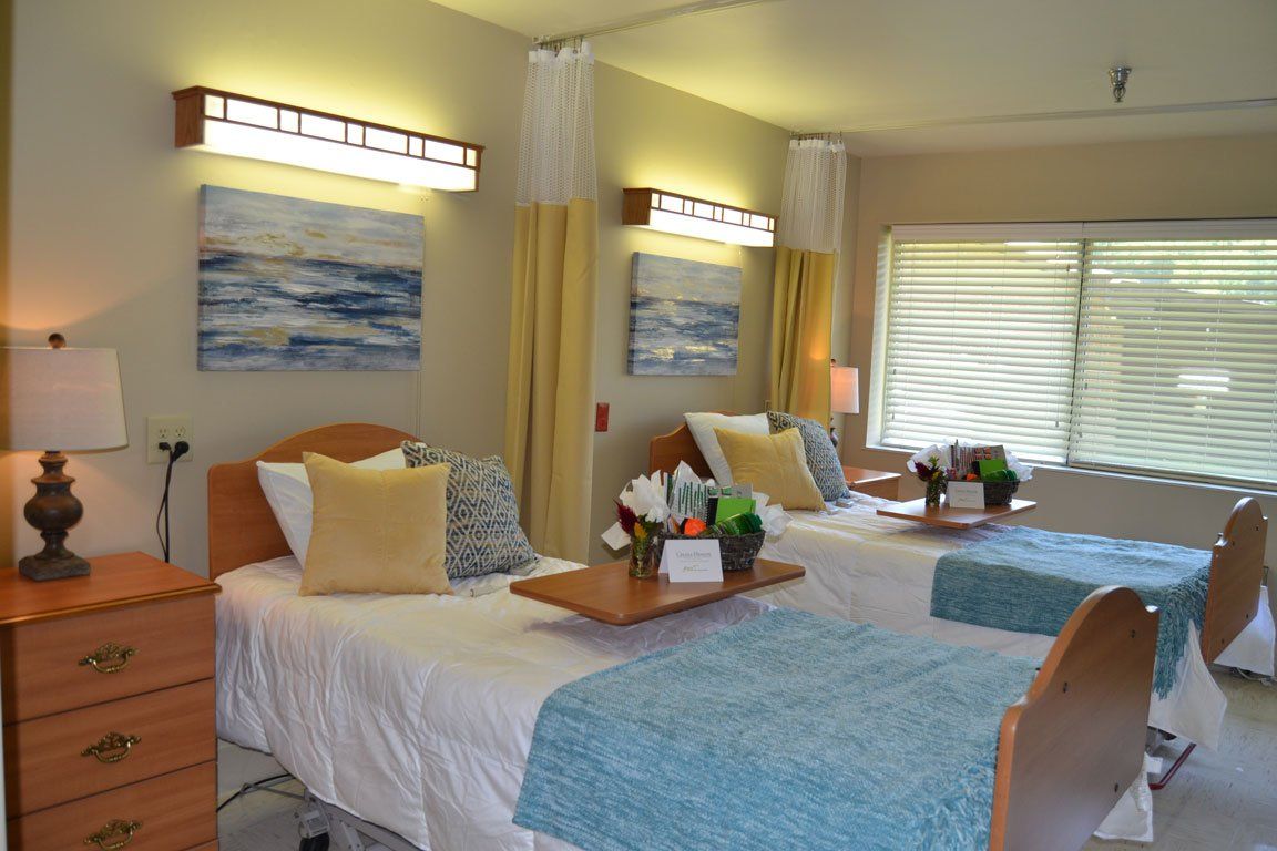 A hospital room with two beds and a dresser.