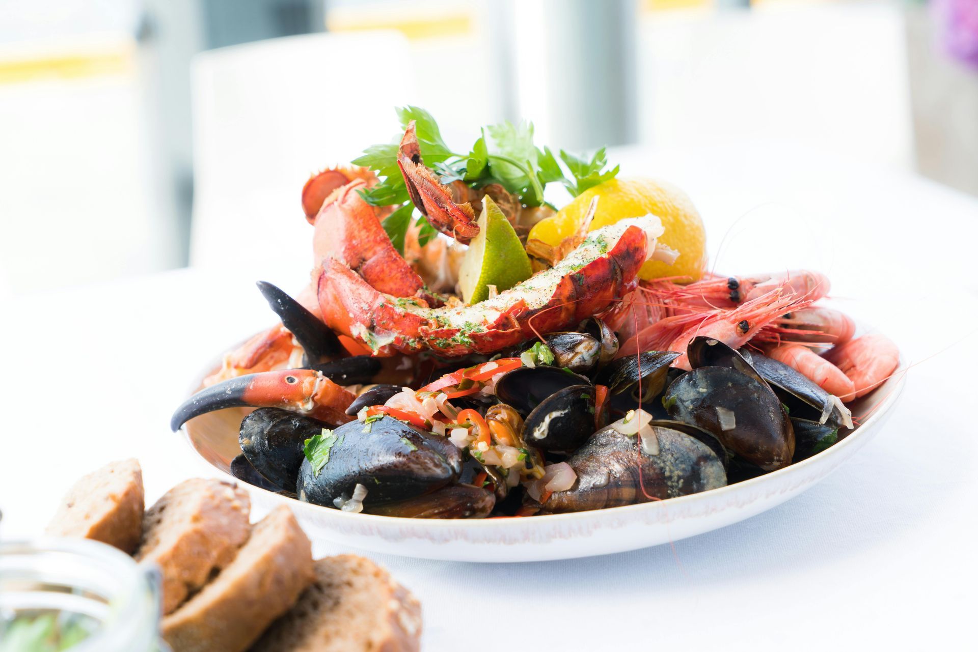 A white plate topped with seafood and bread on a table.