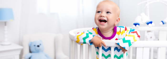 Happy toddler standing in a crib