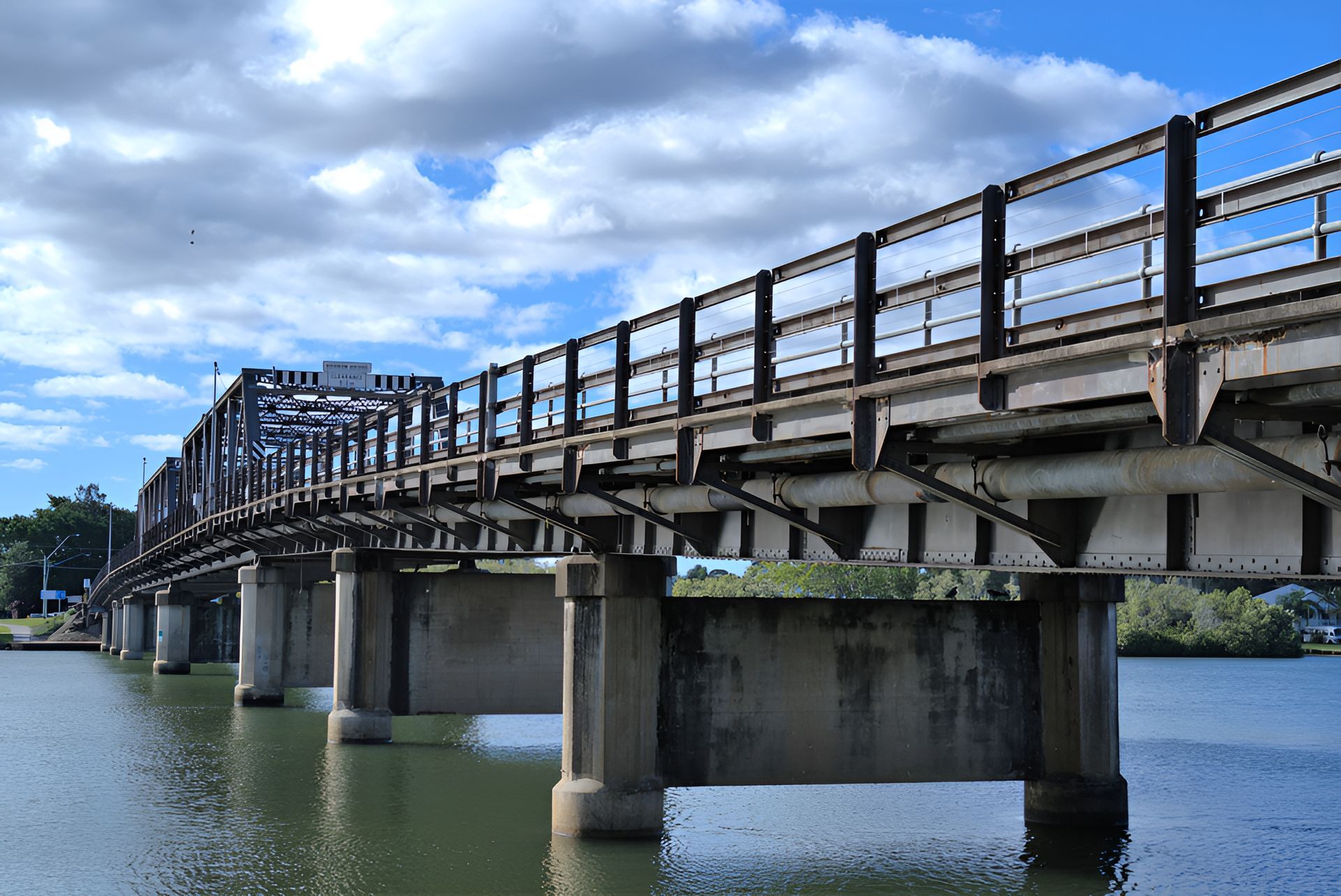 Train bridge over water under a cloudy sky — Stuart Pearce Electrical In Coffs Harbour, NSW