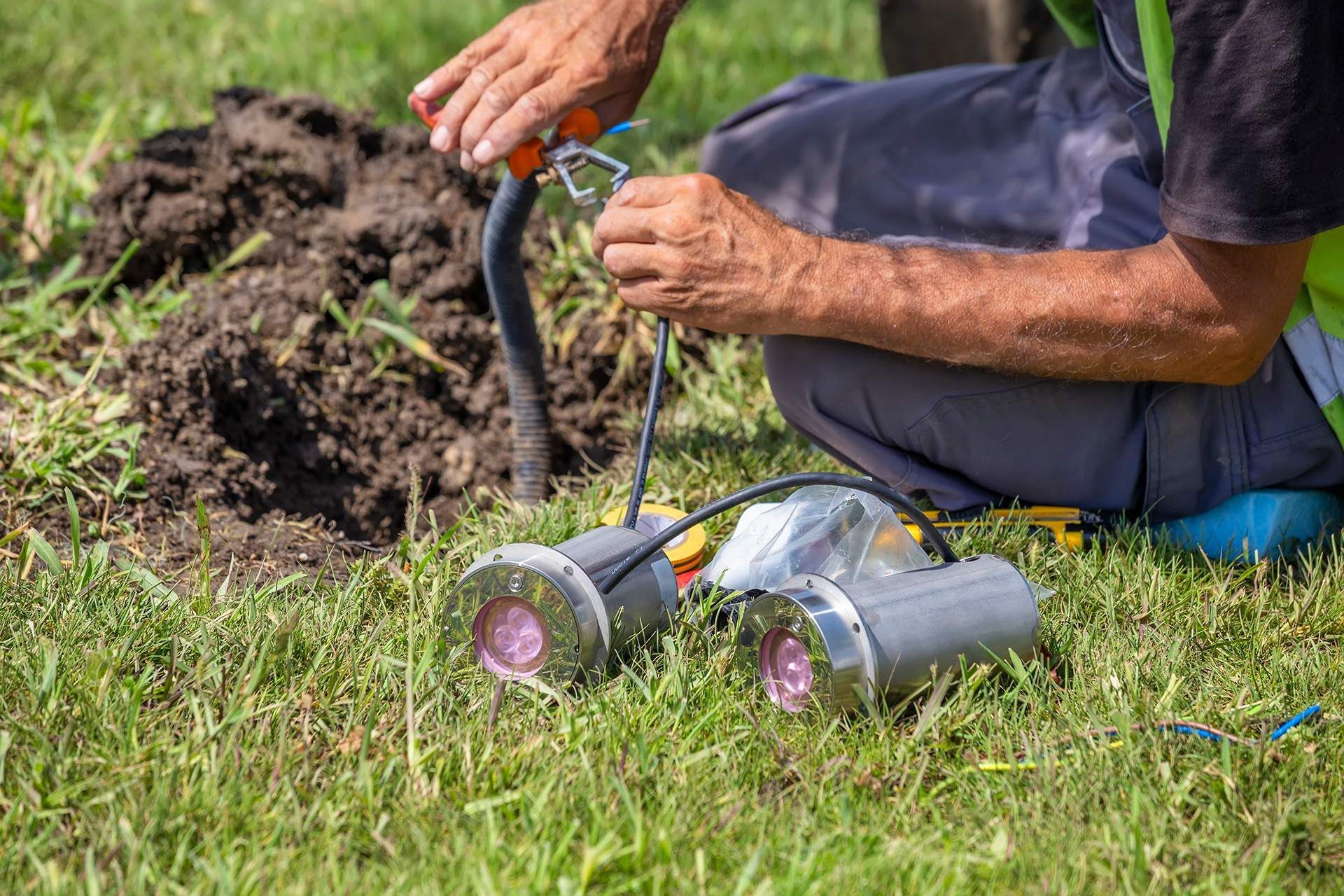 a man is installing a light in the ground .