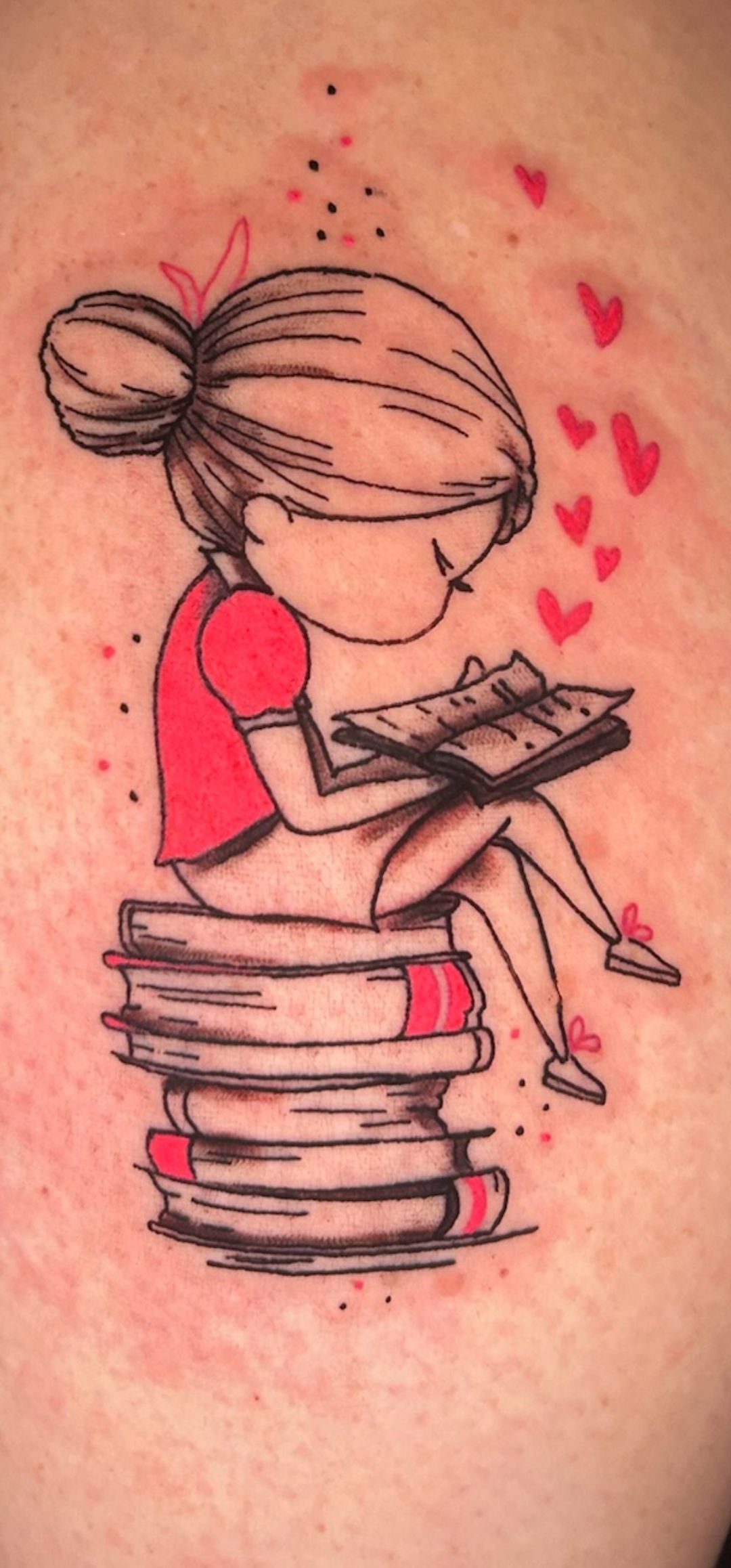 Girl reading on stacked books, sketched tattoo with red accents and floating hearts