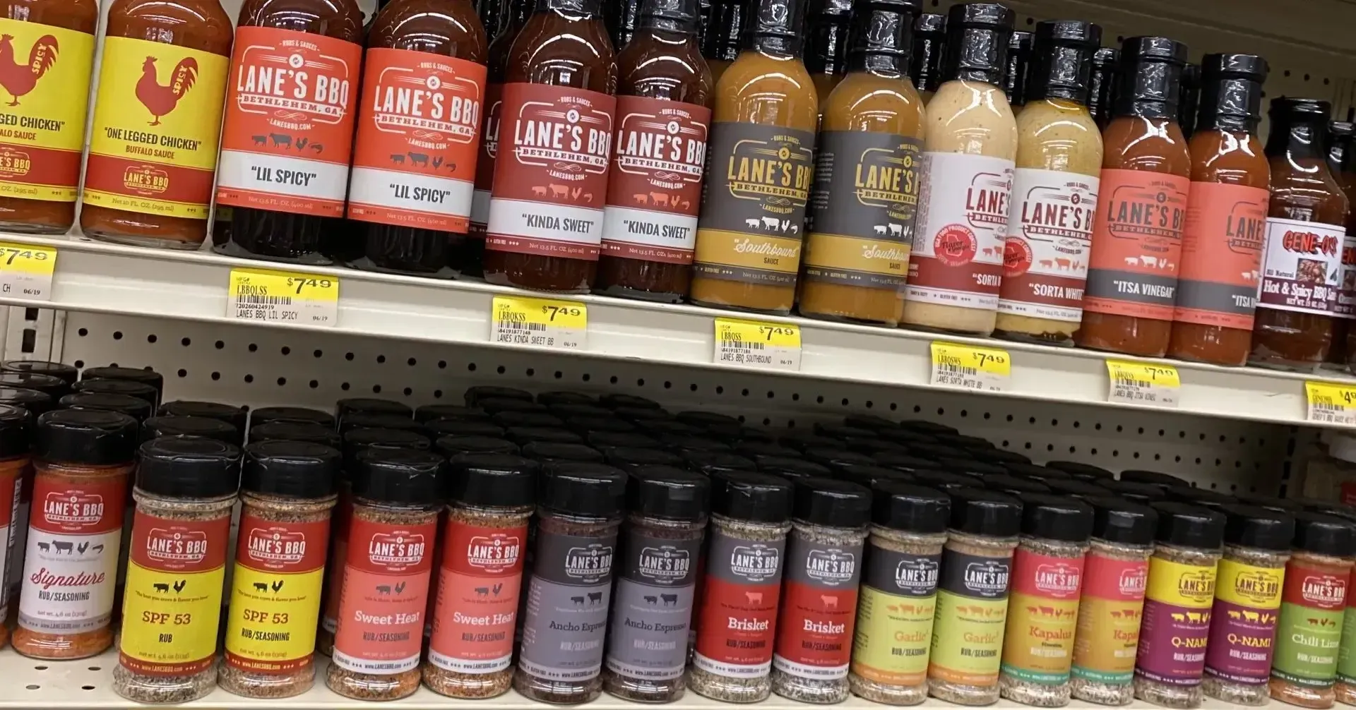 A store shelf filled with bottles of hot sauce and spices