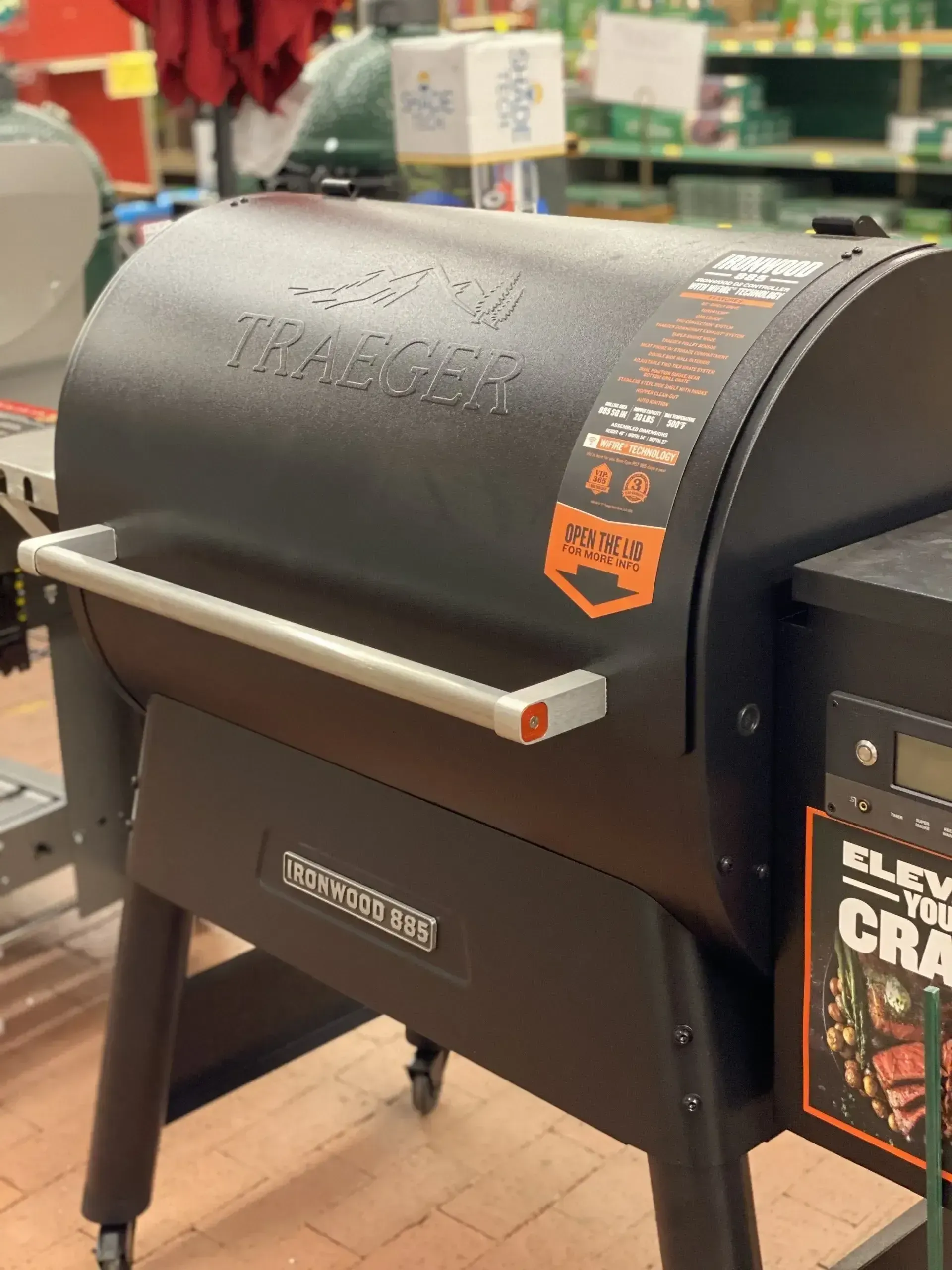 A black grill is sitting on a wooden floor in a store.
