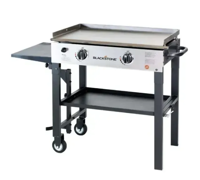 A blackstone grill is on a cart with wheels
