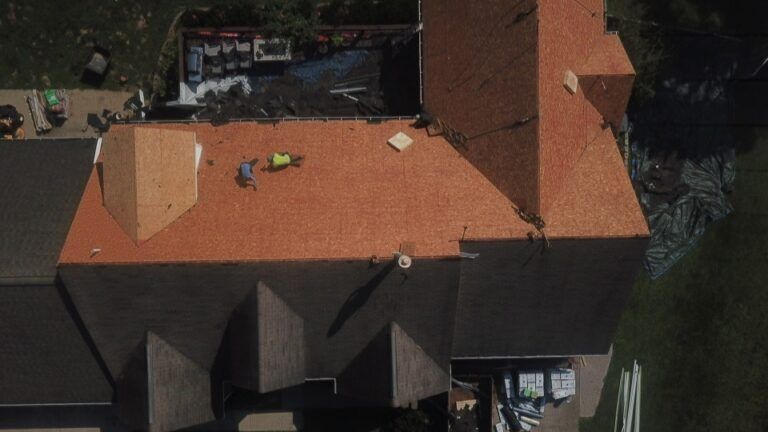 An aerial view of a house with a new roof being installed.