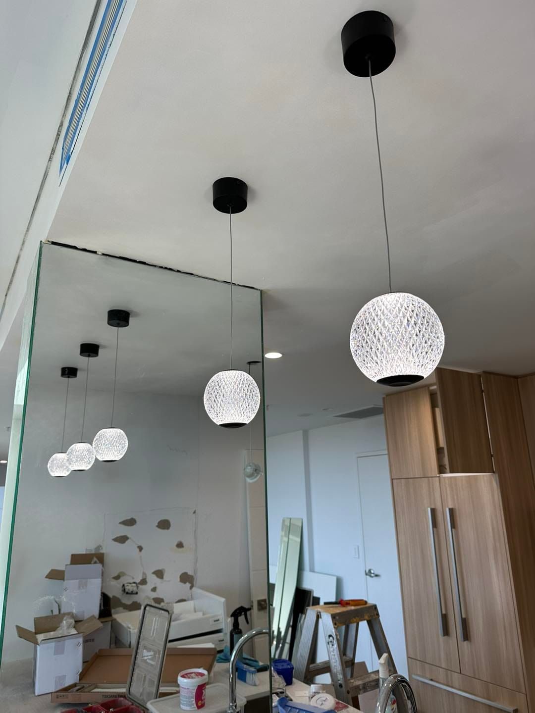 Partially Renovated Room With Hanging Globe Pendant Lights and a Large Wall Mirror — SparkSafe Electrical in Bulli, NSW