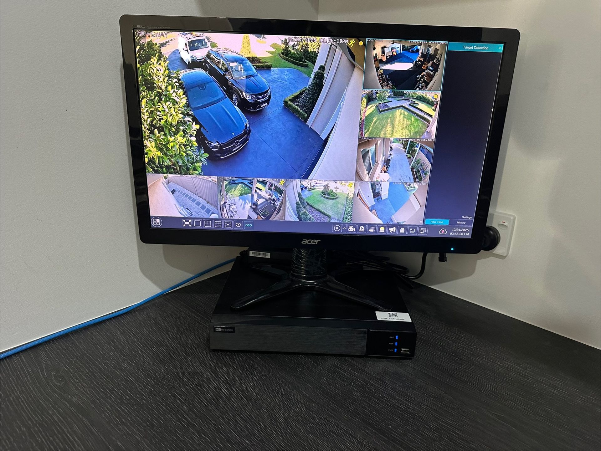 Security Camera Monitor Displaying Multiple Views of a Driveway and Yard — SparkSafe Electrical in Dapto, NSW